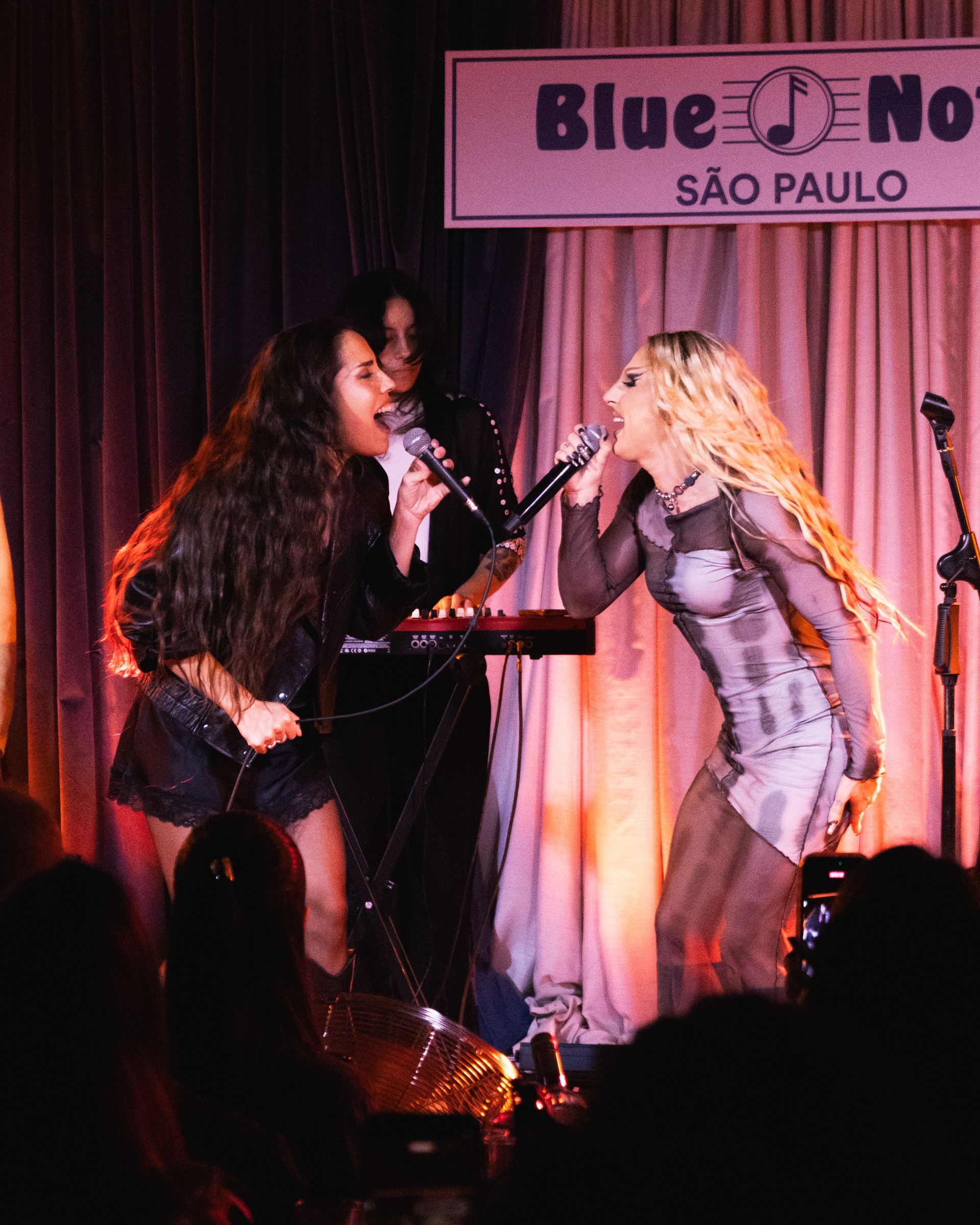 Myra Ruiz e Diego Martins cantando olhando uma para a outra no palco do Blue Note São Paulo